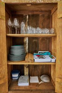 una estantería de madera con platos y vasos. en Casa Baleia - Caraíva - 100m da Igreja, en Caraíva