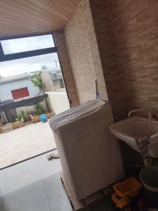 uma casa de banho com um lavatório branco e uma janela em Sobrado Praia Nova Tramandaí em Tramandaí