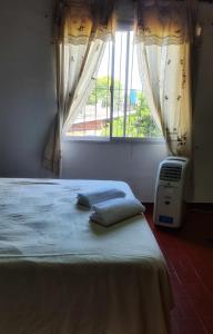 Schlafzimmer mit einem Bett und einem Fenster mit Vorhängen in der Unterkunft Depto confortable para 4 Personas in Posadas