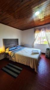 ein Schlafzimmer mit einem großen Bett und einer Holzdecke in der Unterkunft Depto confortable para 4 Personas in Posadas