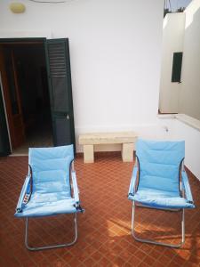 zwei blaue Stühle und eine Bank in einem Zimmer in der Unterkunft Appartamento vista mare a 10 minuti da Castro Marina in Andrano