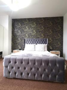a bedroom with a large bed with a large wall at Cutlass Court Apartments by Comfort Zone in Birmingham
