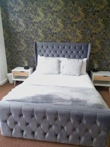 a bed with a tufted headboard in a bedroom at Cutlass Court Apartments by Comfort Zone in Birmingham