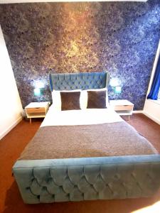 a bedroom with a large bed with a blue headboard at Cutlass Court Apartments by Comfort Zone in Birmingham