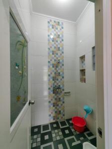 a bathroom with a shower with a red bucket at Pondok Syariah Hadikusuma 