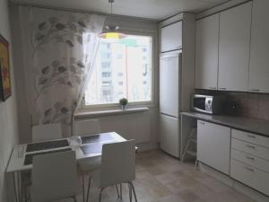 a kitchen with a table and chairs and a window at Valoisa & tilava 3.krs kaksio, lasitettu parveke in Kouvola
