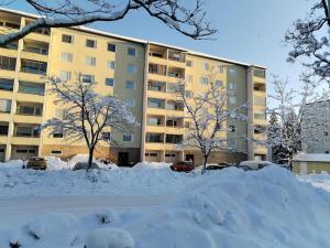 科沃拉的住宿－Valoisa & tilava 3.krs kaksio, lasitettu parveke，建筑物前的一堆积雪
