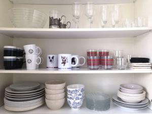 a shelf filled with plates and cups and dishes at Valoisa & tilava 3.krs kaksio, lasitettu parveke in Kouvola