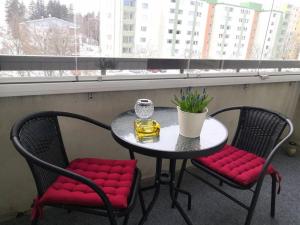 科沃拉的住宿－Valoisa & tilava 3.krs kaksio, lasitettu parveke，一张桌子、红色软垫椅子和一张桌子及一个窗口