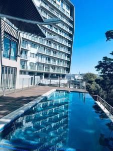 a large building with a swimming pool in front of a building at Delight Luxurious Apartments in Johannesburg