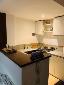 - une cuisine avec un comptoir noir et une cuisinière dans l'établissement Green Wood, à Rosario