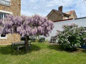 een seringen boom met een picknicktafel in een tuin bij Villa Les Capucines in Vaires-sur-Marne