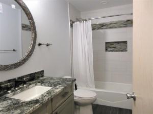 a bathroom with a sink and a toilet and a mirror at Close Walk To The Beach, The Perfect Home For A Single Family, in Harvey Cedars +24 photos