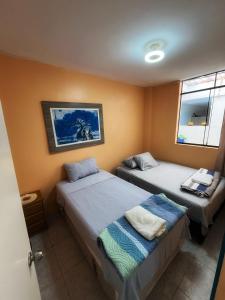 1 dormitorio con 2 camas y ventana en Casa de Playa Barranca, en Barranca