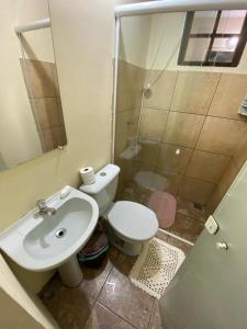 a bathroom with a toilet and a sink and a shower at Quarto Ponta Negra in Angra dos Reis