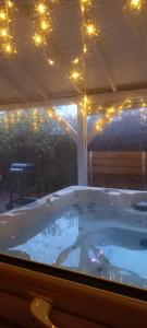 皮特洛赫里的住宿－The Retreat Cabin，庭院内一个带灯光的按摩浴缸