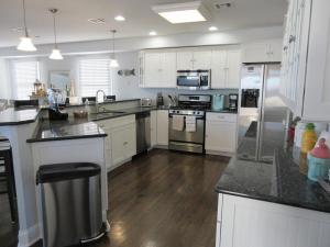 une cuisine avec des armoires blanches et des appareils en acier inoxydable dans l'établissement Single Family On The Ocean Side Block In Brant Beach Very Nicely Appointed!, à Brant Beach 14 autres photos