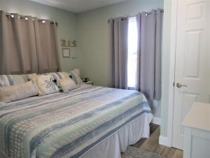 1 dormitorio con cama y ventana en 2 Bedroom Condo Totally Renovated On Ocean Block In Ship Bottom, en Ship Bottom