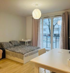 sypialnia z łóżkiem, stołem i oknem w obiekcie cybernetyki2 street INN near airport w Warszawie