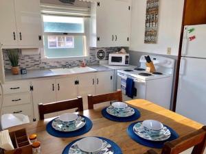 una cocina con una mesa de madera con platos azules y blancos. en 2 Bedroom Condo Totally Renovated On Ocean Block In Ship Bottom, en Ship Bottom