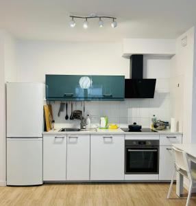 a kitchen with white cabinets and a refrigerator at cybernetyki2 street INN near airport in Warsaw