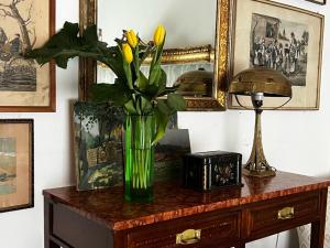 un vase avec des fleurs jaunes assis sur une table dans l'établissement La casa di Bedelia, à Capodimonte