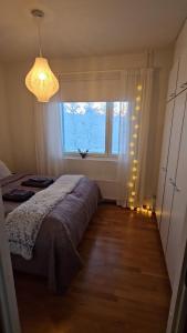 een slaapkamer met een bed en een groot raam bij Adorable Arctic Apartment with sauna in Rovaniemi