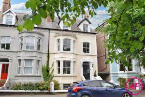 a blue car parked in front of a house at Willesden, Flat 2, A 1 Bedroom flat right in the heart of Llandudno in Llandudno