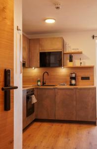 a kitchen with stainless steel appliances and wooden cabinets at Appartementhaus Bergkristall in Kartitsch