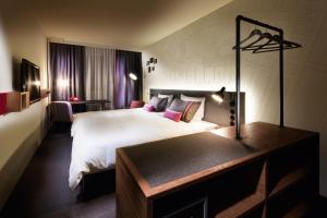 um quarto de hotel com uma cama grande e uma secretária em pentahotel Brussels City Centre em Bruxelas