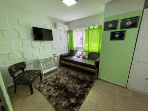 a small living room with a couch and a tv at Green Depto in Córdoba