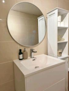 a bathroom with a white sink and a mirror at Homestay close to the hospital and Alton Towers with resident dog and cat in Stoke on Trent