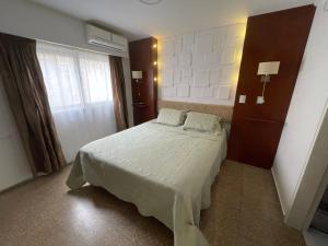 a small bedroom with a bed and a window at Green Depto in Córdoba