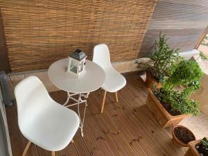 una mesa blanca y 4 sillas en un patio en Cosy Studio for couples 2 min from Mades Beach, en Ligaria