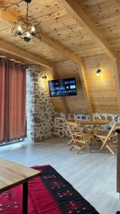 a room with a wooden ceiling with a tv in it at Windmill Shkodra Gesthouse Camping & Grill in Shkodër