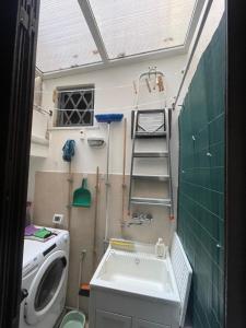 a bathroom with a sink and a washing machine at Dimora delle Sciare - Centro Storico in Catania