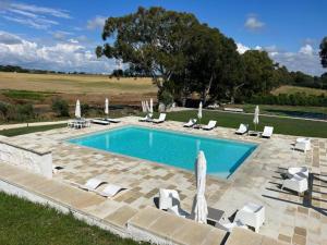 a swimming pool with chairs and umbrellas at Euphoria Resort in Olgiata