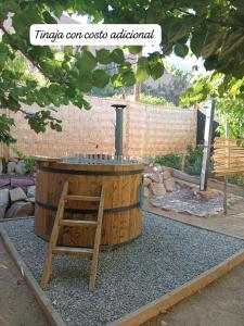 barril de madera con silla en un jardín en Puma Cottage, en Horcón