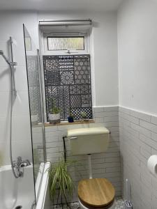 a bathroom with a toilet and a window at Charming studio Apartment in London in London