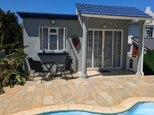 une maison avec une terrasse et une piscine dans l'établissement Captains Quarters Poolside Villa, à Flic-en-Flac