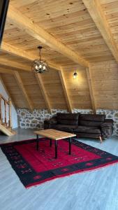a living room with a couch and a table at Windmill Shkodra Gesthouse Camping & Grill in Shkodër