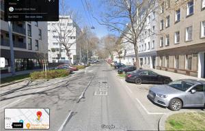 an empty city street with cars parked on it at Danube family deluxe retreat in Vienna