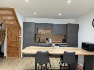 una cucina con un grande tavolo e sedie in legno di MAISON DE VILLAGE a Chambon-le-Château Altre 3 foto