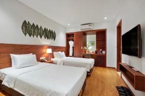 a hotel room with two beds and a flat screen tv at Classic Hotel Hanoi in Hanoi