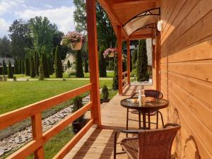 eine Holzterrasse mit einem Tisch und Stühlen in der Unterkunft Forest Edge Cottage in Riga