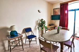 un soggiorno con tavolo da pranzo e sedie di Marsalforn Seaview Apartment in a quiet area a Qbajjar Altre 3 foto
