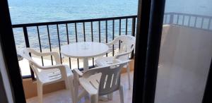 un tavolo e delle sedie su un balcone con vista sull'oceano di Marsalforn Seaview Apartment in a quiet area a Qbajjar