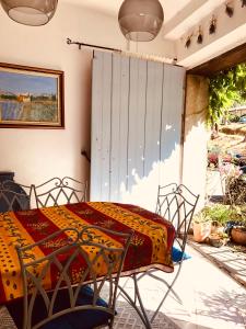 un patio con mesa y sillas en un porche en La maison Vigne Vierge, en Lagrasse