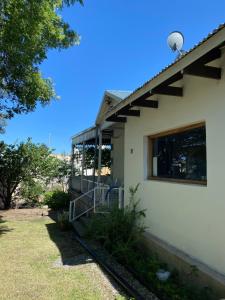 una casa con una ventana en un lado en Alojarte en Punilla- Casona Azul hasta 12 personas en Huerta Grande