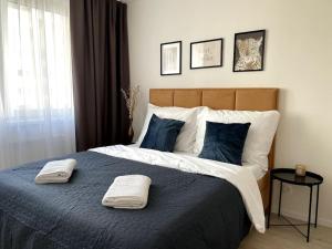 a bedroom with a large bed with two towels on it at SkyNest Apartments in Bratislava